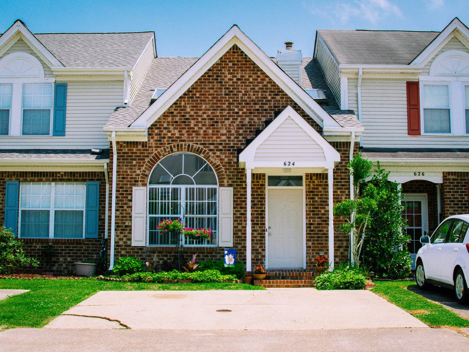 A brick home with an arched window and a white front door